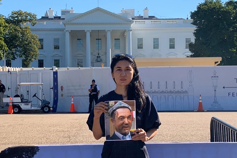 Nur Iman holds a picture of her father in front of the White House in Washington in September. COURTESY OF NUR IMAN
